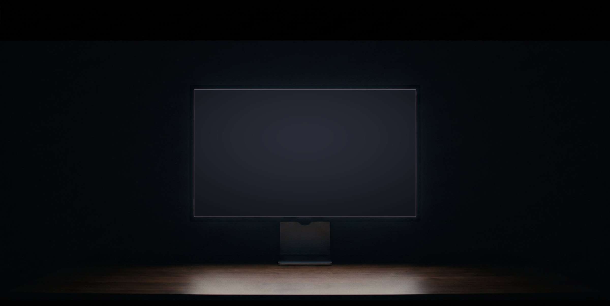 A monitor glowing in a dark study, photographed straight on